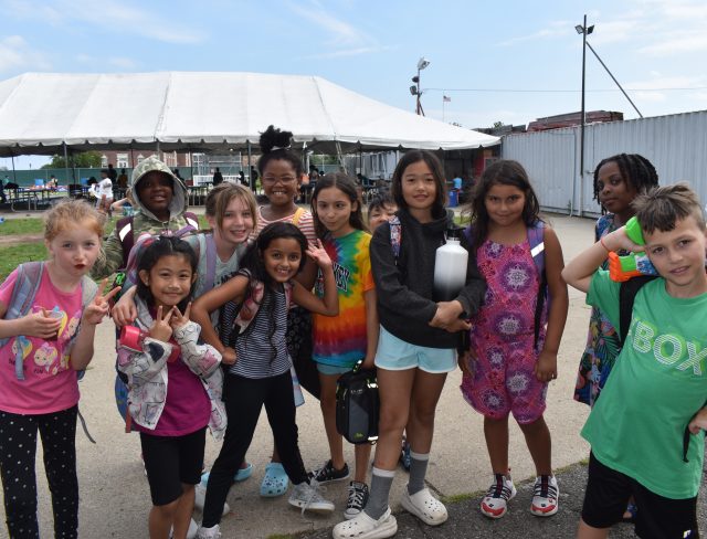 Young kids wearinga rainbow of colors posing for a photo in Campland